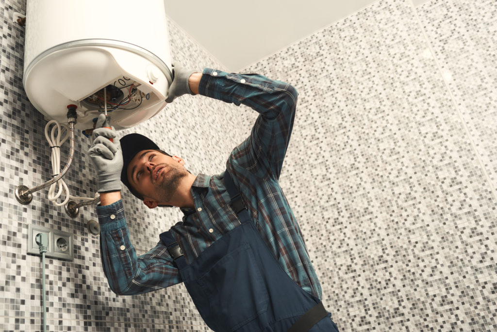 Plumber installing electric heating boiler