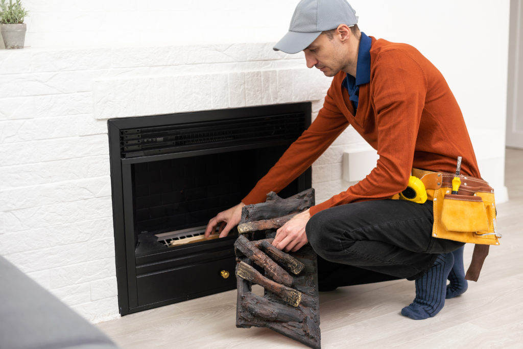 Professional technician installing electric fireplace in room